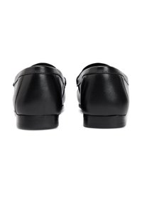 Μαύρα δερμάτινα μοκασίνια με λεία υφή, στρογγυλερή μύτη, χαμηλό τακούνι και διακριτική ραφή στο πίσω μέρος.