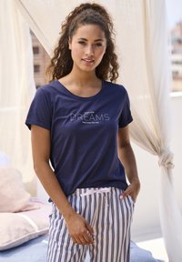 Navy blue cotton t-shirt with short sleeves and crew neck, featuring white embroidered text "follow your DREAMS they know the way." Paired with striped pajama pants.