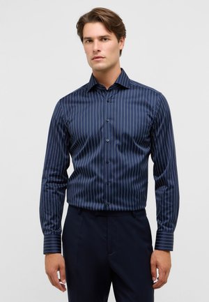 Marineblauwe gestreepte overhem shirt met lange mouwen, knoopsluiting aan de voorkant en klassieke kraag. Dunne witte verticale strepen voegen textuur toe.