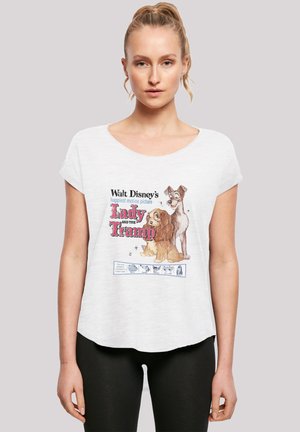 Hvit T-skjorte med korte ermer som har et fargerikt tegneserie-design av to hunder og teksten "Lady and the Tramp." Myk, avslappet passform.