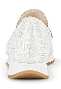 Witte sneaker met een gestructureerde bovenkant, tan accenten, een gevoerd kraagje en een flexibele zool. Heeft een laag profiel en ademend materiaal.