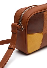 Smeđa kožna torba sa žutim akcentima, pravokutnog oblika, sa gornjim zatvaračem i podesivim remenom. Vidljive teksturirane površinske detalje.