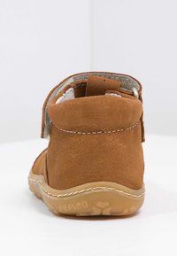 Kahvi nahkakengät pyöreällä takana, tarrakiinnitys, valkoinen vuori ja joustava kumipohja, jossa on tekstuuripinta.