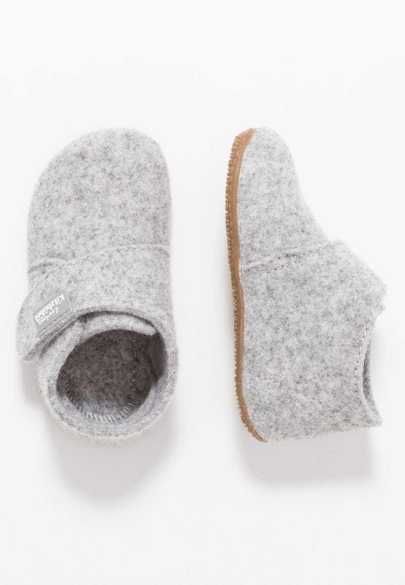 Chaussons pour tout-petits en tissu doux gris clair avec semelles en caoutchouc marron et une bride en velcro sur le côté, montrés vues de dessus et de côté.