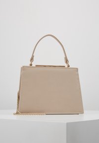 Beżowa torebka strukturalna z sztucznej skóry, z uchwytem od góry, złotymi detalami oraz odczepianym łańcuszkiem.
