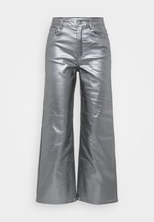 Zilveren, wijde broek gemaakt van een metallic, glanzende stof met een zachte textuur. Heeft twee voorzakken en een knoopsluiting in de taille.