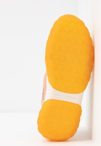 Rosa Wildleder-Sneaker mit einer strukturierten weißen Mittelsohle und einer leuchtend orangefarbenen Gummiaußensohle mit runden Profilen. "MAISON SCOTCH" auf der Mittelsohle geprägt.