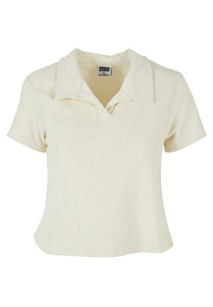 Krémové polo tričko s krátkým rukávem a límečkem. Vyrobeno z měkké, strukturované látky; má volný střih a minimalistický design.