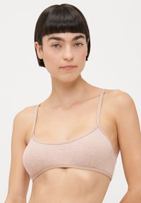Light pink ribbed bralette with thin straps and a subtle logo. Smooth texture and elastic band for comfort and support.