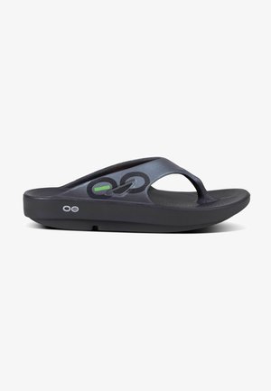 Des sandales en flip-flop noires avec une semelle texturée, dotées d'une bride brillante et d'un design de logo circulaire sur le dessus. Disponibles dans un style moderne et épuré.