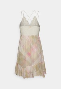 Kevyt hihaton mekko, jossa on teksturoitu valkoinen yläosa ja virtaava, monivärinen hame pastellivärisissä vaaleanpunaisissa, beigen ja vaaleankeltaisten geometrisissa kuoseissa.