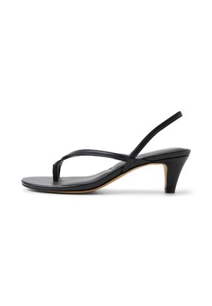 Czarny sandał na niskim obcasie typu kitten heel ze skóry, z paskiem między palcami i paskiem na piętę, minimalistyczny design na białym tle.