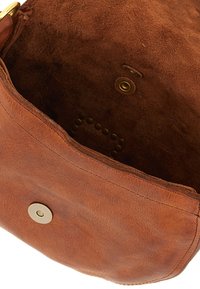 Borsa a tracolla in pelle marrone con una texture morbida, forma arrotondata e chiusura a scatto magnetica. Presenta un interno semplice con un dettaglio in ottone.