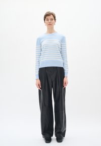 Maglione a righe blu cielo realizzato in morbido tessuto, con collo a giro e polsini a costine, abbinato a pantaloni in pelle neri a vestibilità morbida.