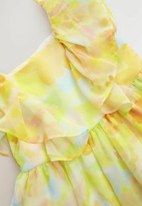 Robe à motif floral avec des manches à volants superposées. Fabriquée en tissu léger, dans des teintes jaunes, vertes et pastel. Dispose d'une taille froncée.