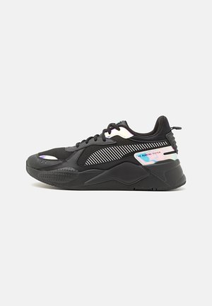 Czarny sportowy sneaker z odblaskowymi białymi i opalizującymi akcentami, grubą podeszwą i sznurowanym designem, pokazany z boku na jednolitym tle.