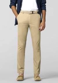 Beige chinos with a straight fit, featuring belt loops and a woven belt. Paired with casual slip-on shoes and a blue shirt.
