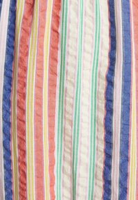 Tissu à rayures verticales dans les tons bleu, orange, vert, jaune, rose et blanc, présentant une texture légèrement froissée.