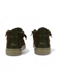 Scarpe alte in suede marrone con un colletto in tessuto testurizzato, dettagli verdi e suola in gomma marrone chiaro. Presentano un logo sul retro.