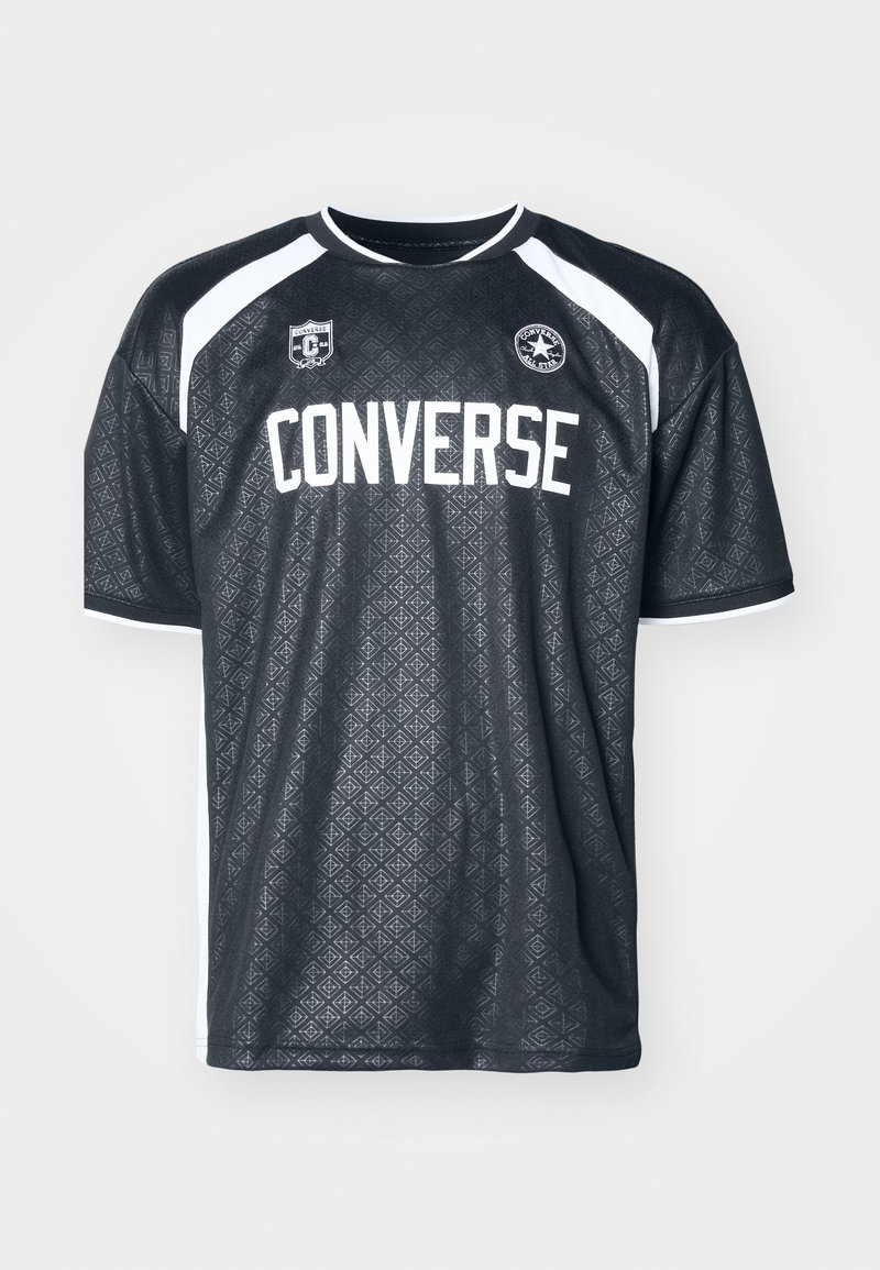Camiseta deportiva negra con un patrón geométrico, acentos blancos en los hombros, gran texto "CONVERSE" en la parte delantera y logotipo en el pecho.