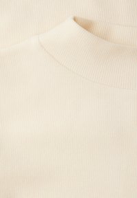 Jasnobeżowy prążkowany top z wysokim kołnierzem, miękką fakturą i gładkim wykończeniem, z delikatnymi szwami podkreślającymi konstrukcję.