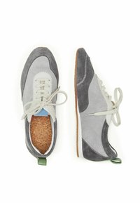 Scarpe in suede grigie e grigio chiaro con un design con lacci, bordi curvi e soletta in sughero, dotate di anelli per il tallone verdi e cuciture a contrasto.