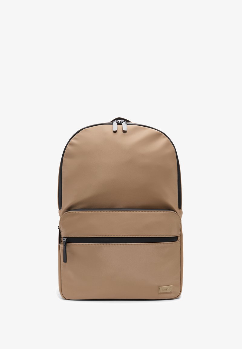 Beige nylon batoh s zaobleným tvarem, s přední kapsou na zip, matně černými akcenty a stříbrným kováním na dvojitých zipsech.