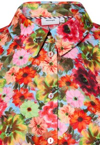 Collared shirt with white buttons featuring a vibrant floral pattern in red, orange, pink, green, and blue hues.