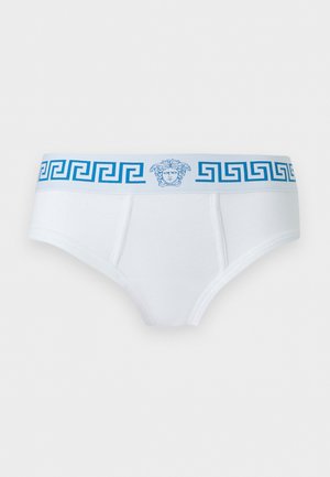 Slip blanc avec ceinture à motif clé grecque bleue et emblème de tête de Méduse centré sur la bande.