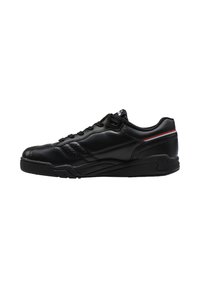 Sneaker in pelle nera con una superficie liscia, dettagli perforati, suola piatta e una striscia di accento rossa e bianca sulla parte superiore.