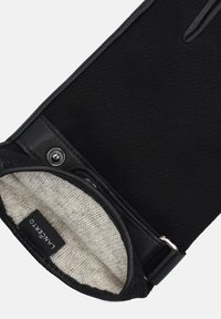 Czarny skórzany portfel o textured powierzchni, z miękką szaro-skalą podszewką i zapięciem na zatrzask. Etykieta jest częściowo widoczna.