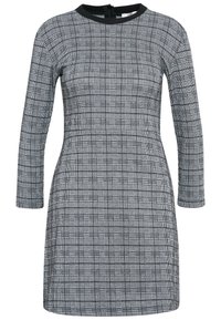 Robe à motifs noir et blanc avec manches longues, encolure ronde et une silhouette ajustée. Dispose d'une fermeture éclair dans le dos.