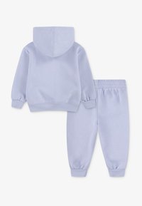 Lyslilla bomulds-hoodie med en frontlomme og matchende svedbukser. Begge har elastiske manchetter og en elastic waistband for komfort.