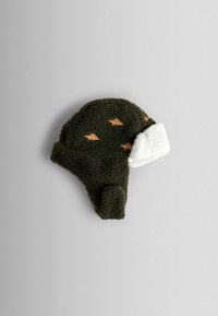 Cappello in pile verde con motivi di animali arancioni e orlo in pelliccia sintetica bianca, progettato con paraorecchie per calore e comodità.