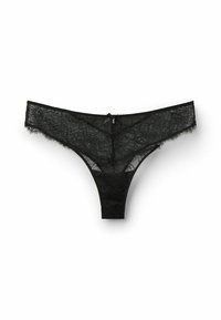 String en dentelle noire avec motif floral, bords festonnés et un petit nœud en satin à l'arrière. Tissu doux avec une texture transparente.