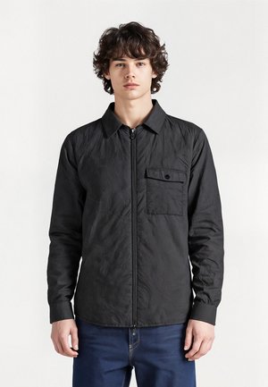 Black, lightweight jacket with a zip front, pointed collar, long sleeves, and a patch pocket on the left side. Textured, slightly crinkled material.