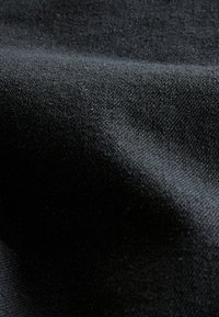 Czarny tekstylny materiał o gładkiej fakturze, z delikatnymi wariacjami w odcieniach oraz matowym wykończeniem.