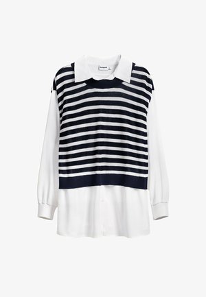 Tamsiai mėlynos ir baltos spalvų dryžuota megzto audinio viršutinė dalis su balta marškinėlių palaidine po ja; turi klasikį apykaklę ir ilgomis rankovėmis.