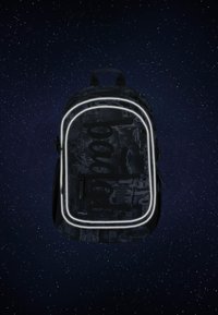 Zaino nero con un motivo a circuito testurizzato, contorno bianco illuminato, tasca frontale con zip e spallacci doppi.