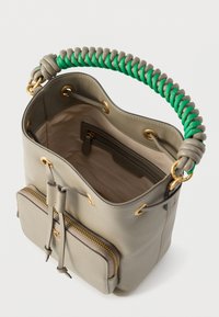 Saco tipo balde em couro cinza claro com uma alça trançada verde, detalhes em dourado e um bolso frontal com zipper. Interior forrado em bege.