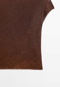 Ruskokas ribbiknitti neule, joka on rento istuvuus ja lyhyet hihat, pehmeällä pinnalla ja hienovaraisella kiillolla.