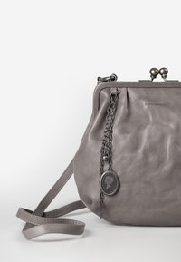 Borsa a tracolla in pelle grigia con design plissettato, dettaglio a catena e pendente decorativo. Caratterizzata da chiusura a pressione e tracolla regolabile.