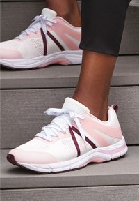 Chaussures de sport légères avec une tige en maille blanche, des accents roses et des rayures bordeaux. Elles présentent des lacets blancs et une semelle rembourrée.