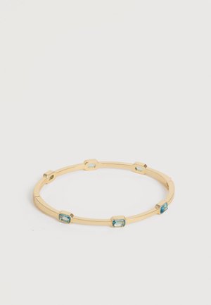 Bracelet jonc en or avec six pierres précieuses bleues rectangulaires espacées uniformément autour du bracelet sur un fond neutre.