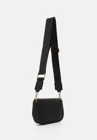 Bolso de piel negra cruzado con un diseño estructurado, herrajes dorados y un acabado texturizado con una correa negra de marca.