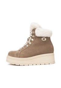 Beige Wildleder-Stiefeletten mit einem Kunstfellbund, robusten Schnürsenkeln, einer goldfarbenen Hardware und einer dicken weißen Plateausohle.