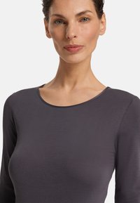 Tmavě šedý dlouhý rukáv top s kulatým výstřihem, vyrobený z hladké tkaniny, těsně padnoucí bez ozdob nebo vzorů.
