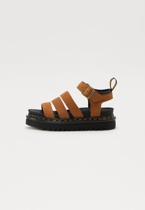 Brun lædersandal med tre remme, justerbar spænde, polstret sort sål og detalje med gule syninger på tyk sort plateau-sål.