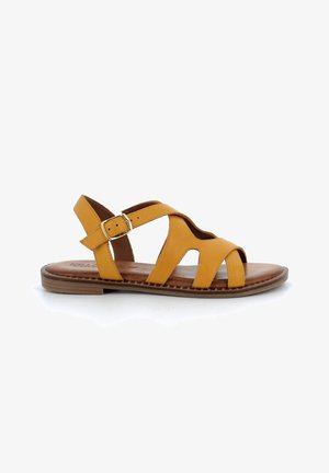 Sandalia de cuero amarillo con múltiples correas cruzadas, hebilla ajustable y suela marrón texturizada. Diseño de punta abierta para ventilación.