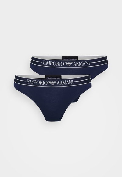 Navyblauwe katoenen stringonderbroek met een contrasterende witte elastische tailleband met het logo "Emporio Armani" en twee horizontale strepen.